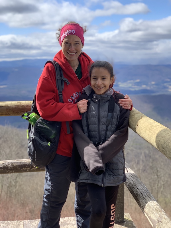 mother and daughter smiling with a mountain view 